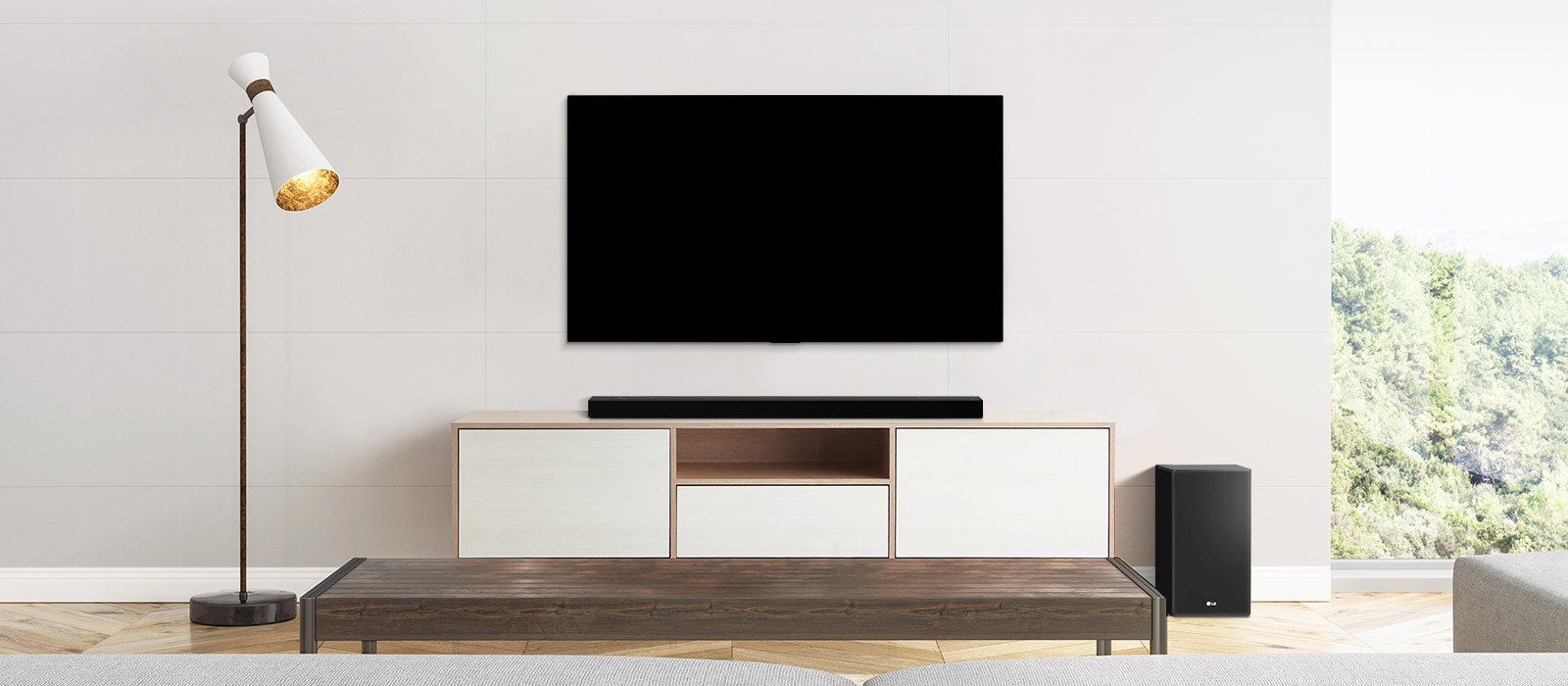 A TV, soundbar, and subwoofer placed in a plain living room.