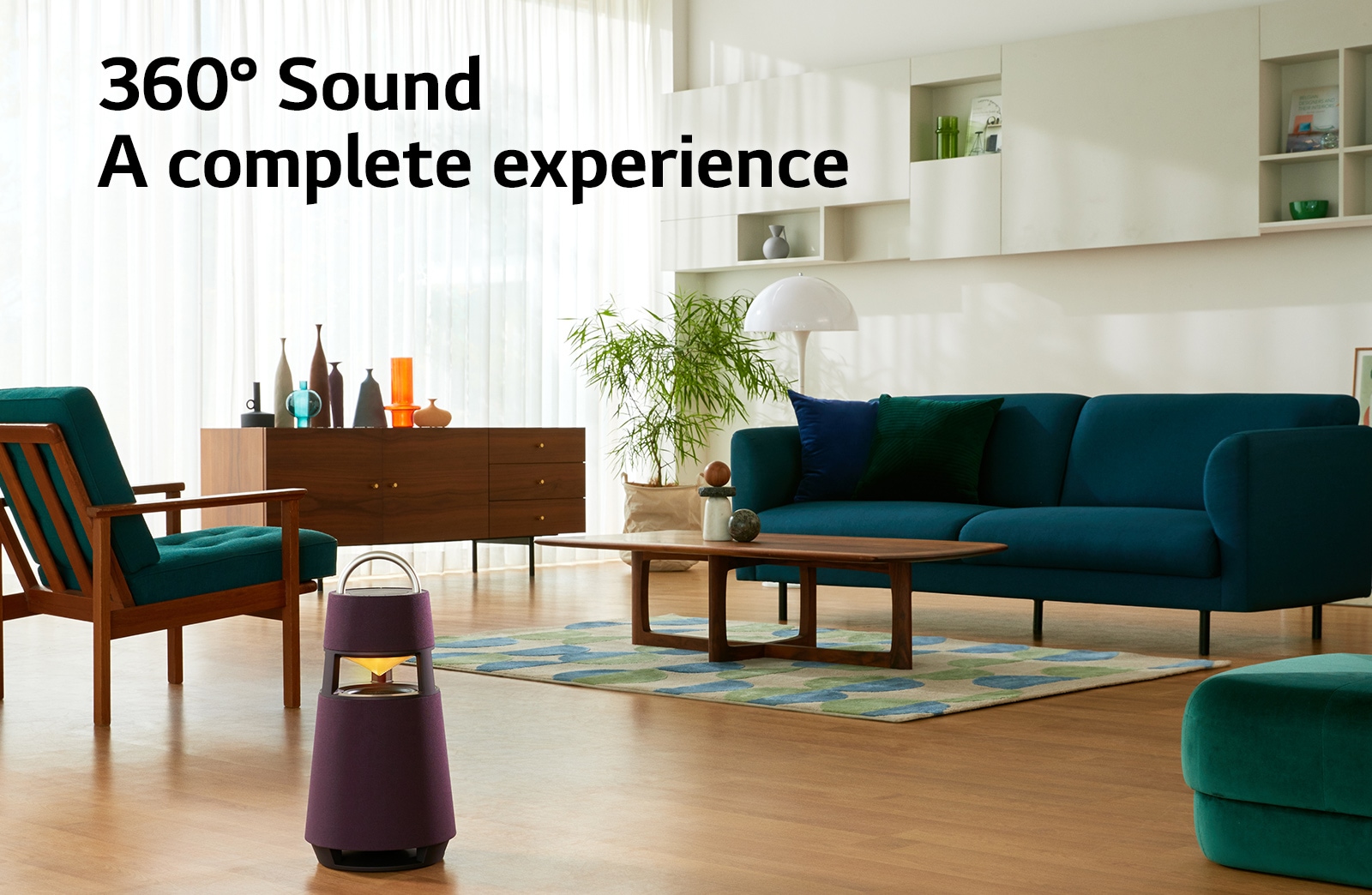 An image of a woman sitting on a sofa listening to music with an XBOOM 360 in front of her.