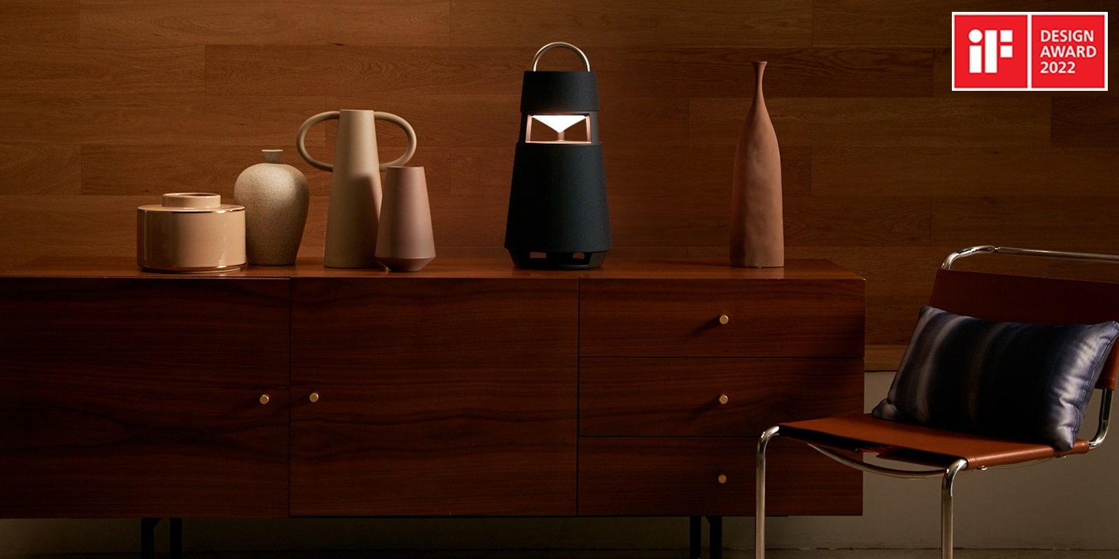 Image of the XBOOM 360 with sculptures on a shelf in a wood-toned interior background.