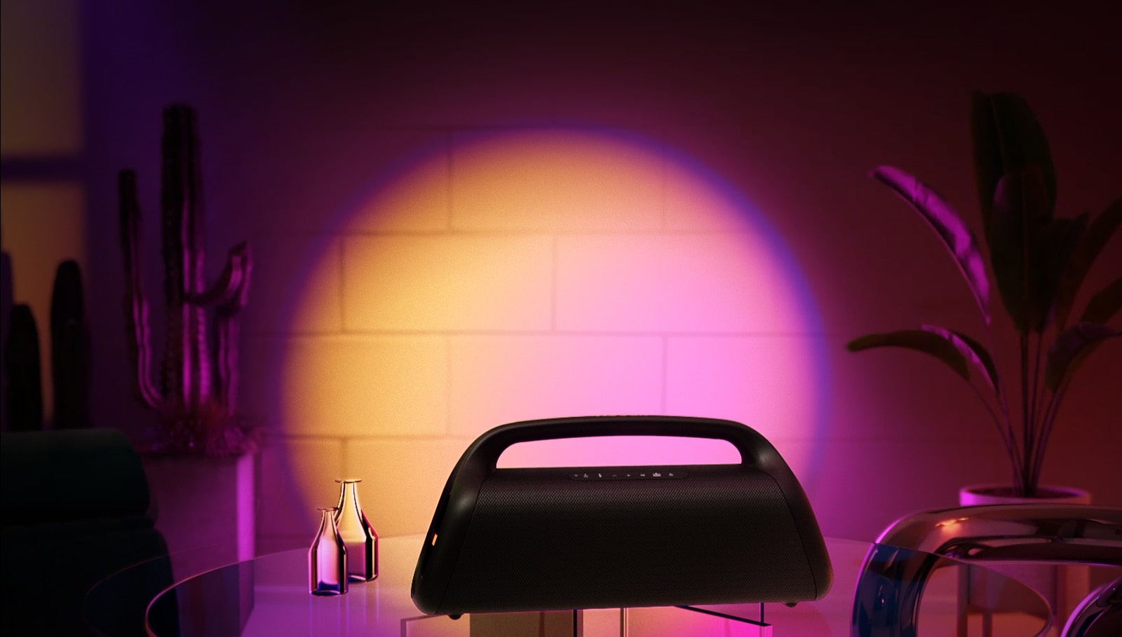 An image of LG XBOOM Go XG9. It's placed on the glass table at home, casts orange and pink gradient stage lighting. 