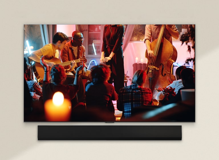 A cozy concert in a living room is playing on the screen. The WOW Interface menu appears as an overlay and the user navigates to soundbar settings.