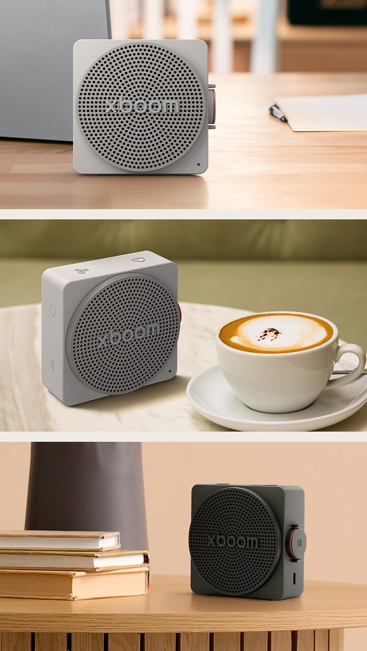 "1) LG xboom mini grey-colored, placed on a desk next to a laptop, showing a compact bluetooth speaker with a lifestyle-fit design for indoor 2) LG xboom mini grey-colored on a coffee table, a compact bluetooth speaker with space-filling sound for both indoor and outdoor use 3) LG xboom mini black-colored placed among books and objects, a small bluetooth speaker designed for convenient everyday use"	