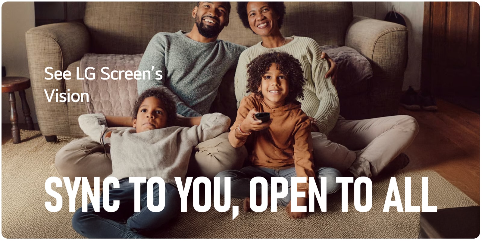 A family sits laughing while the grandfather points the remote outward. 