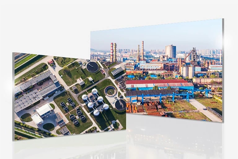 Aerial view showcases a sewage plant with a green area to the left, and slightly overlapping, an industrial site to the right.