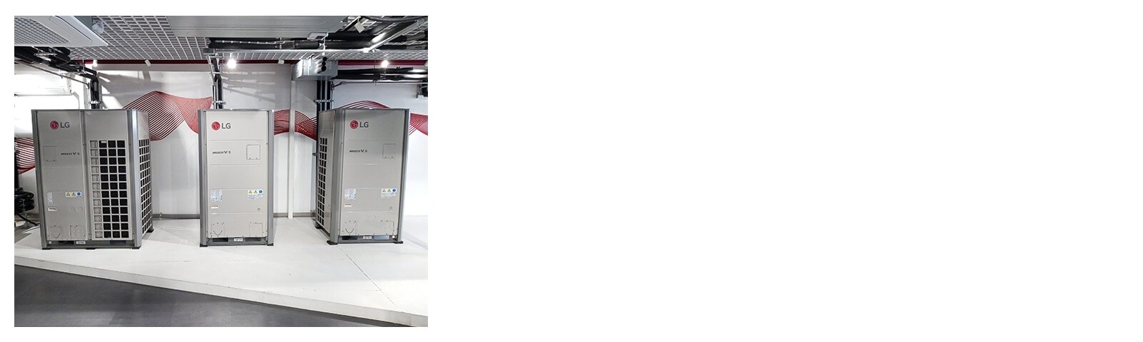 Side by side, one large and two smaller LG Multi V 5 outdoor units each connect to individual pipes descending from the ceiling.