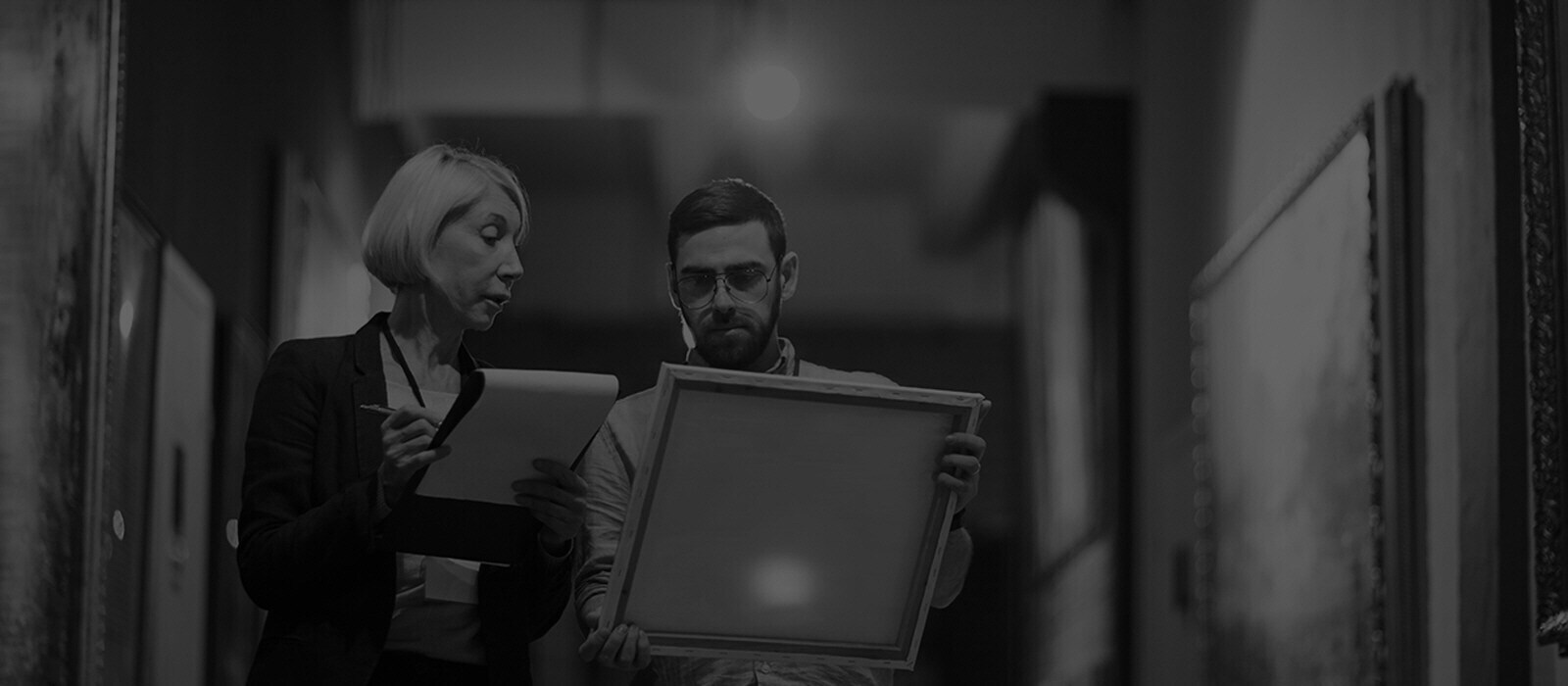 Image of two people looking at a drawing piece in a gallery.