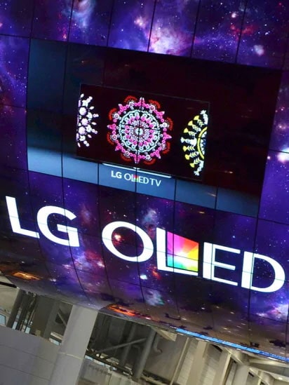 A curved OLED screen installation reading "LG OLED"