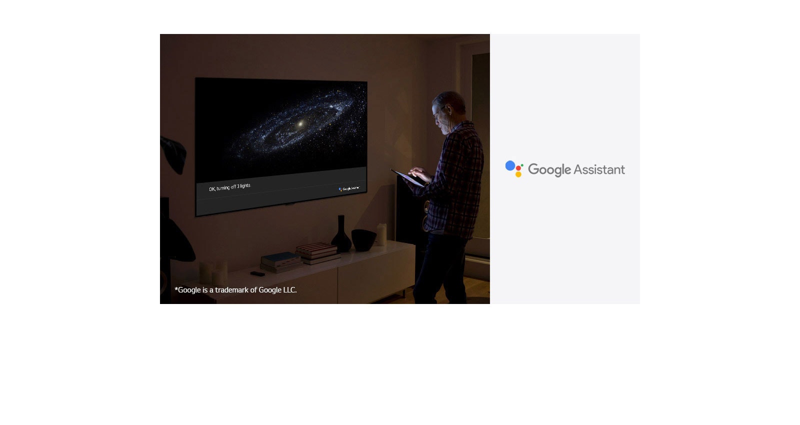 A man is standing in front of TV and ask google assistant to turn off the light