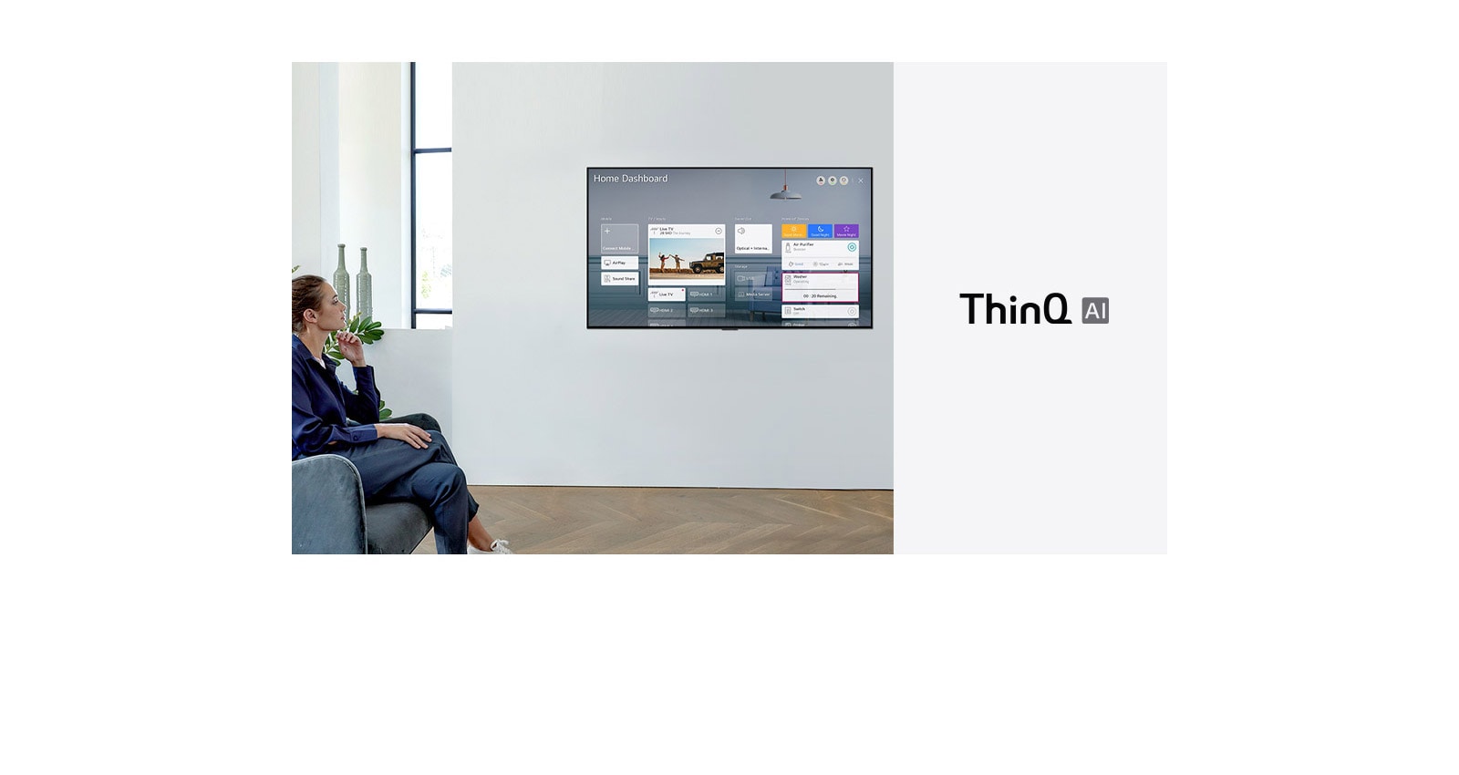 Woman sitting on a chair in the living room with the Home Dashboard on the TV screen