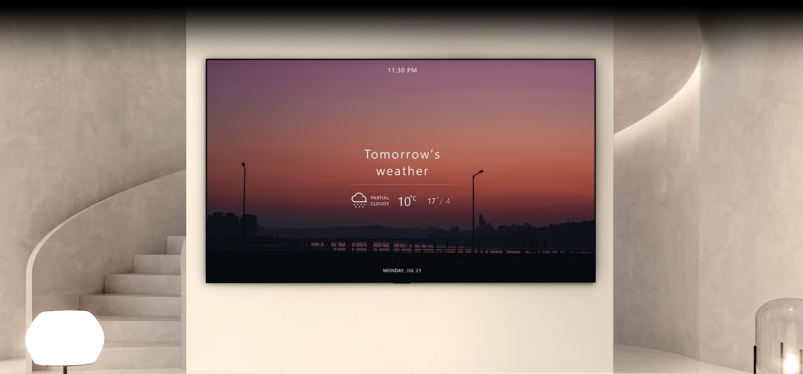 There is a large wall in the space with stairs and lighting, and a TV is hung there. Inside the TV screen, there is a sunset landscape with today's weather information.
