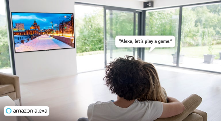 Couple sitting on a couch asking Amazon Alexa to play a game.