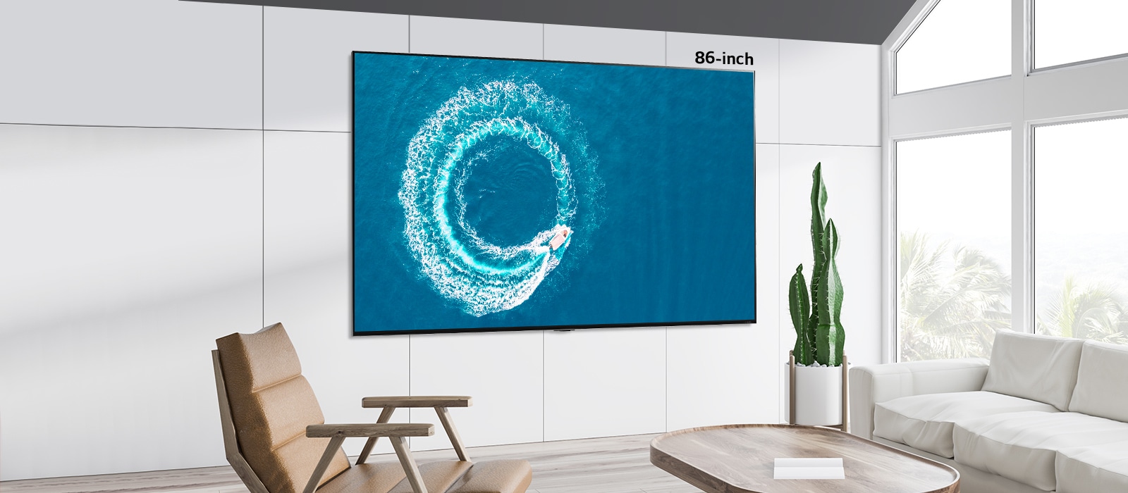 A comparison between 55 inch screen and 86 inch screen which were both hung on the wall displaying a boat making a wave in the middle of sea.