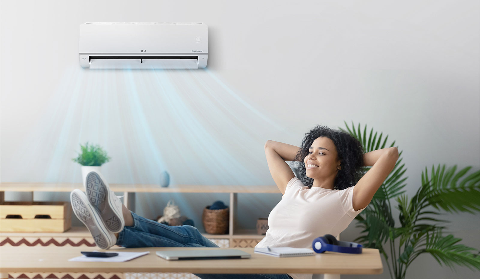Woman closing her eyes and relaxing under a quiet air conditioner.