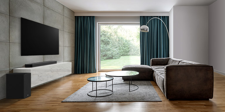 Téléviseur, barre de son et caisson de basse visibles dans un grand salon. Onde en forme de grille sortant de la barre de son et mesurant tout l'espace du salon. 