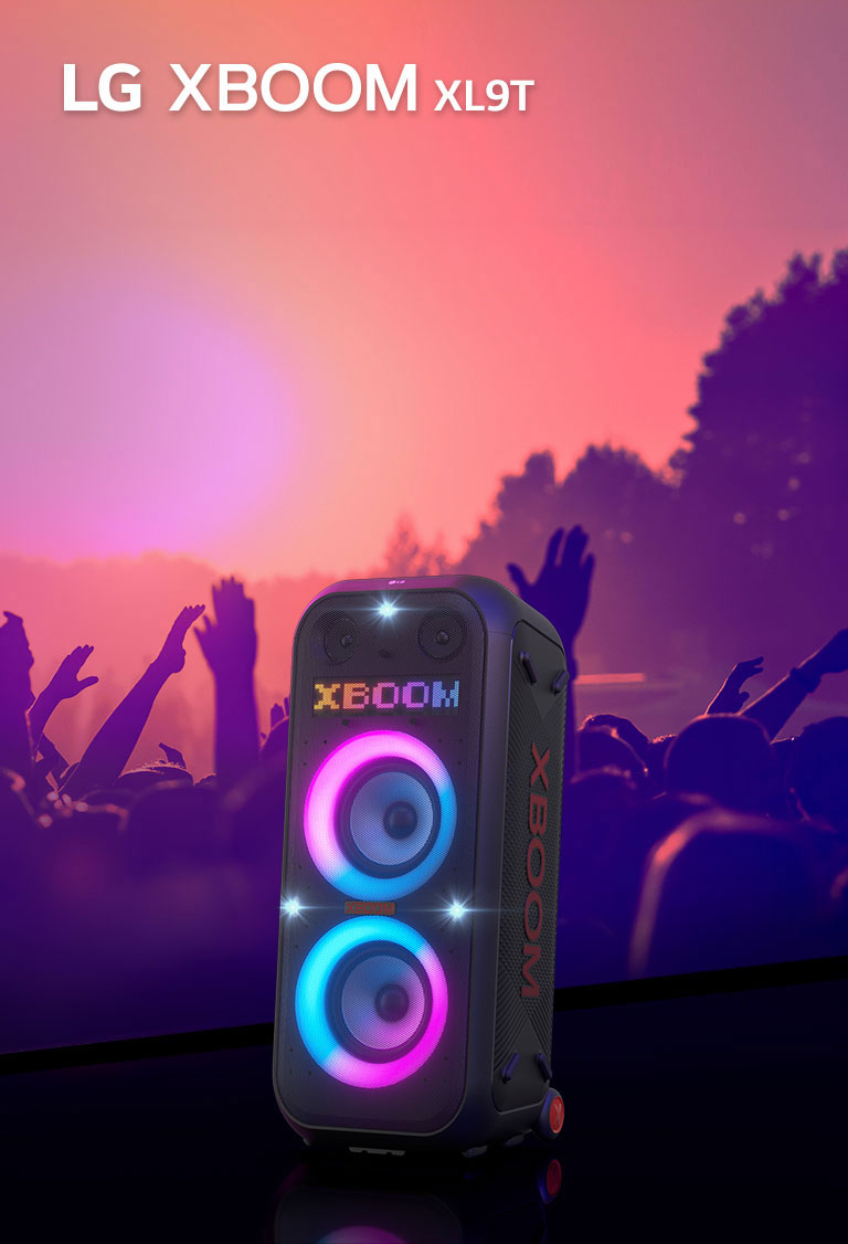 LG XBOOM XL9T est placé sur une surface en vue diagonale. Éclairage multicolore allumé, et l’affichage affiche le mot "XBOOM". Derrière le haut-parleur, une silhouette de gens qui font la fête.