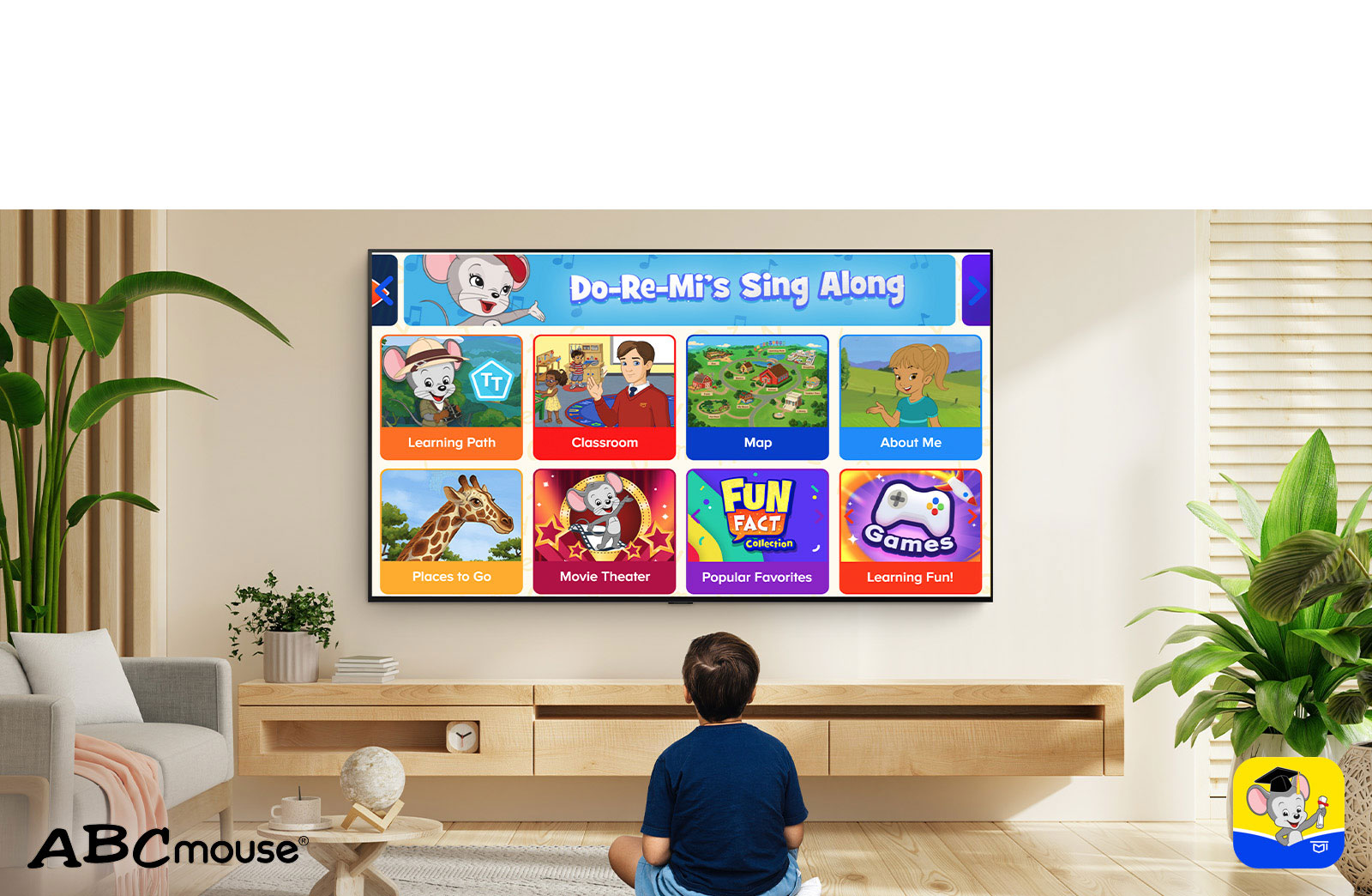Un petit garçon est assis par terre et regarde des contenus éducatifs sur ABCmouse. 