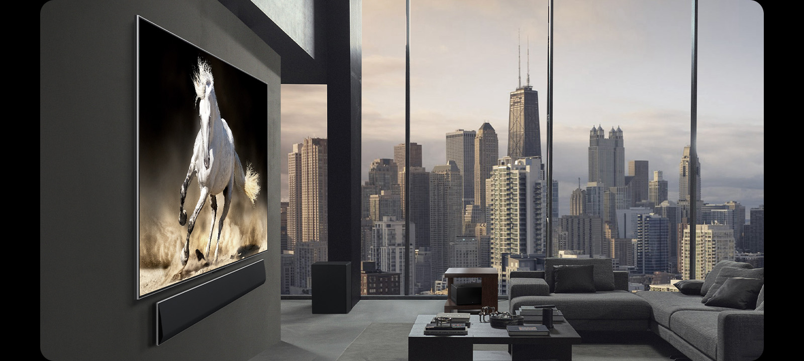 Appartement penthouse haut de gamme. L’horizon urbain est visible dans les baies vitrées du salon. La TV LG True Wireless et la LG Soundbar sont fixées au mur. Le design de l’espace est très sophistiqué et ordonné. Le boîtier Zero Connect est difficilement visible sous l’une des tables de chevet.