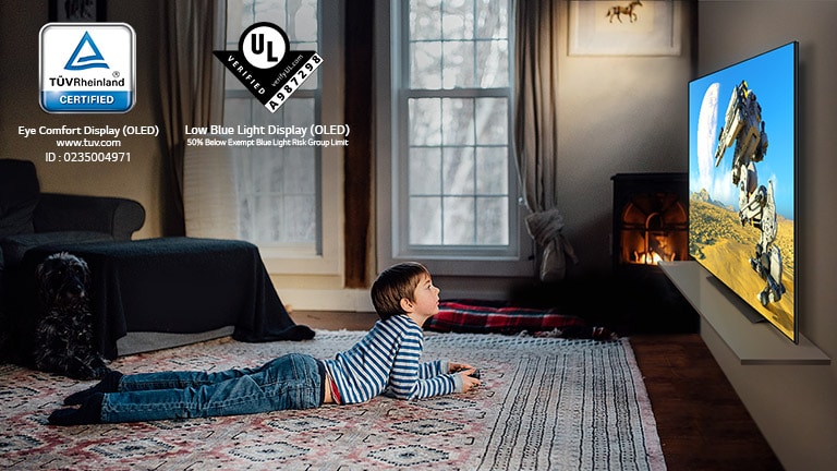 Un enfant couché sur le sol, tenant une manette et jouant à un jeu sur un écran TV