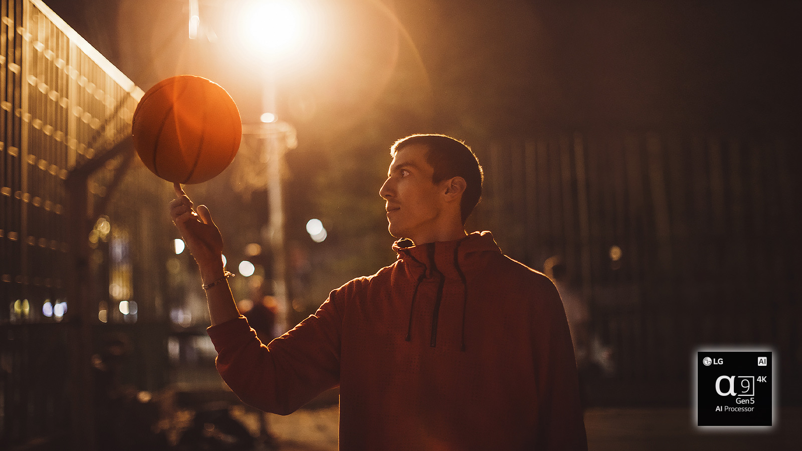 En mann på en basketballbane om natten vender en basketballkule på fingeren