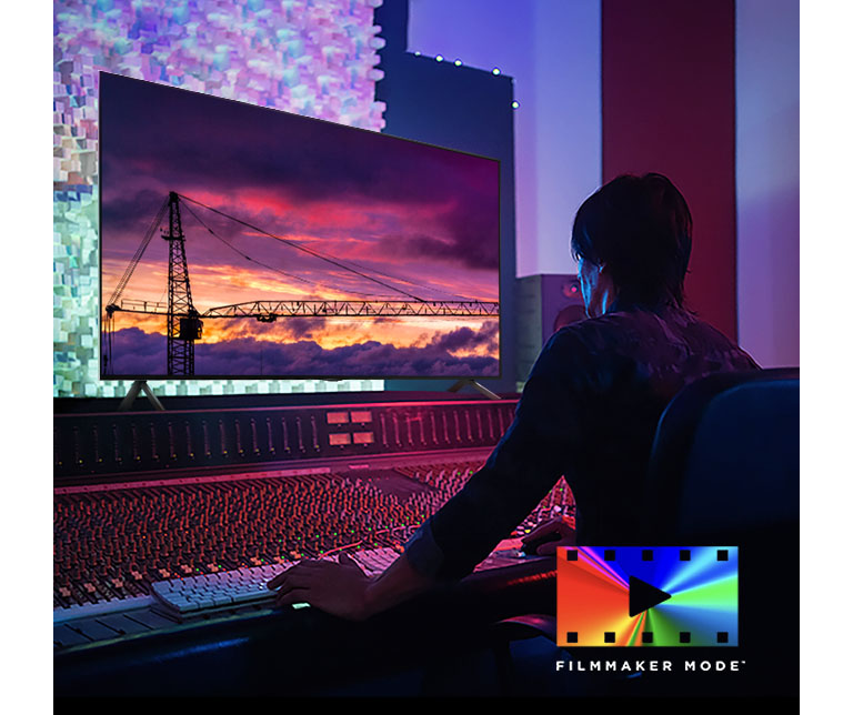 Homme dans un studio de montage sombre regardant un téléviseur LG qui montre le coucher de soleil. En bas à droite de l'image se trouve le logo FILMMAKER Mode.