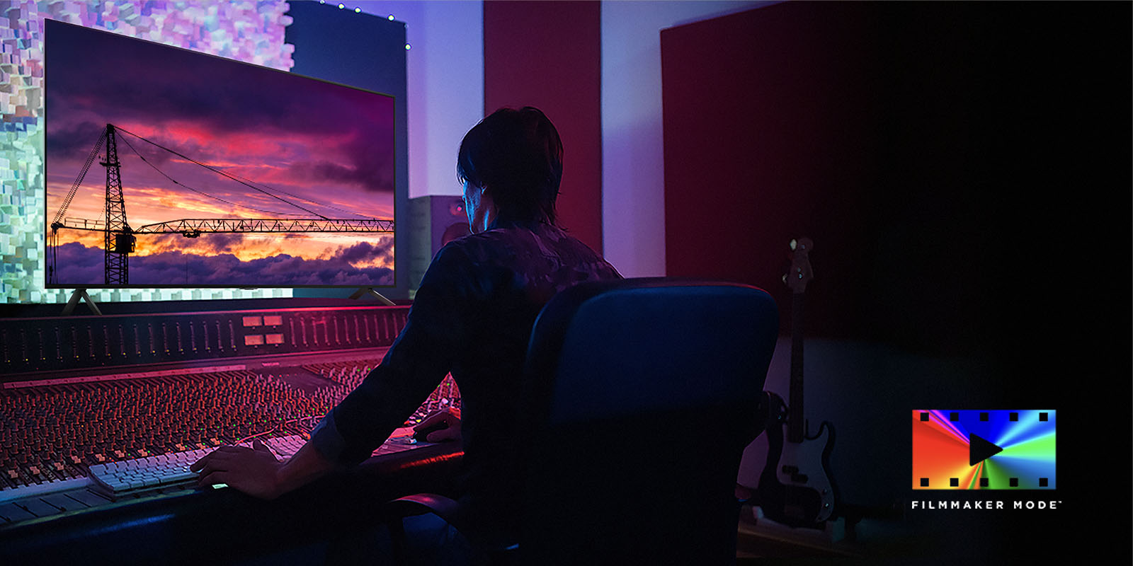 Homme dans un studio de montage sombre regardant un téléviseur LG qui montre le coucher de soleil. En bas à droite de l'image se trouve le logo FILMMAKER Mode.