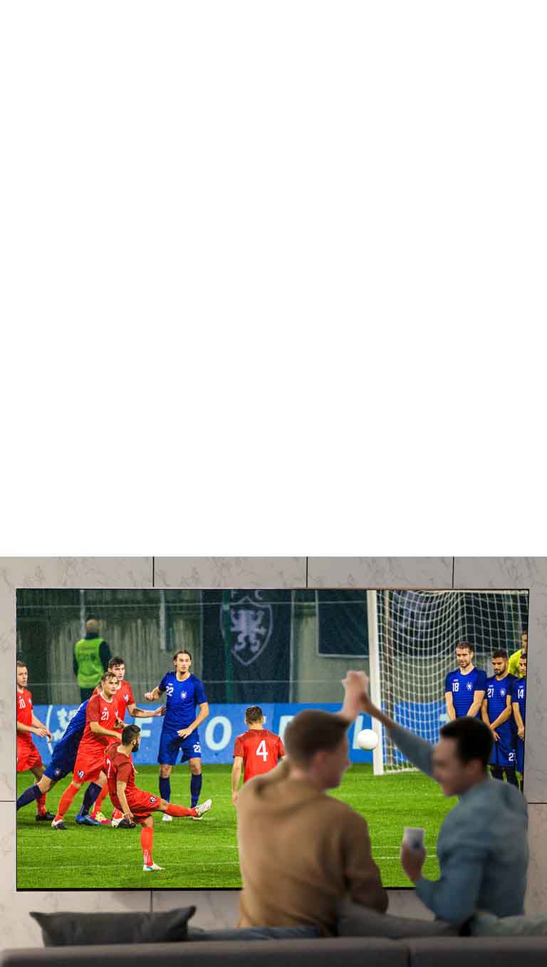 Des personnes regardent un jeu de sport à la télévision dans le salon avec un téléviseur à très grand écran