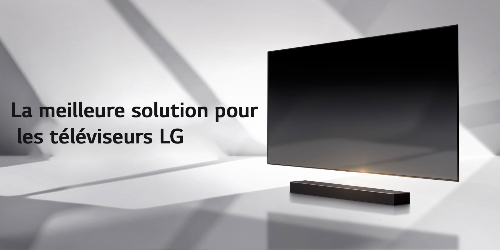 Une barre de son et un téléviseur sont placés sur un sol blanc et une ombre se projette depuis l’extérieur juste derrière.