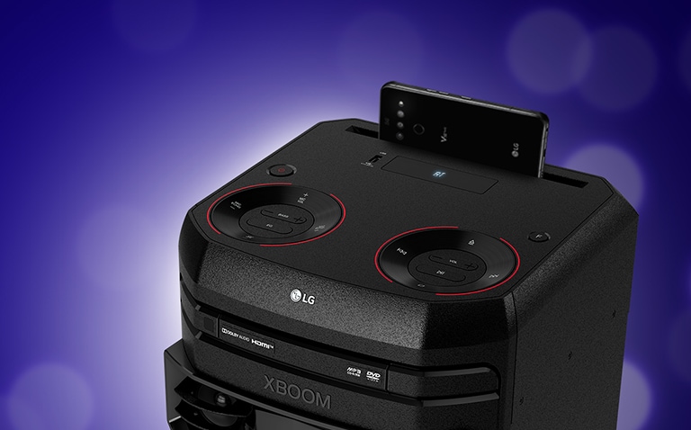 Vue rapprochée du dessus de l’enceinte LG XBOOM. Un smartphone est posé sur l’enceinte LG XBOOM.