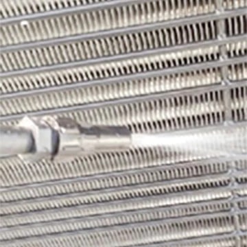 L'ailette de l'échangeur de chaleur est en cours de nettoyage avec de l'eau.