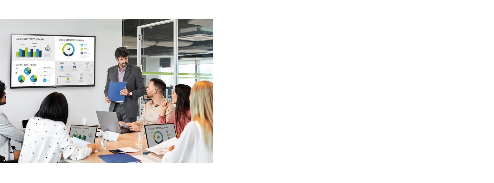 There are 6 people having a meeting and 4 PC screens are simultaneously shared on large signage hanging on the wall through the USB dongle device connected to the personal PCs.