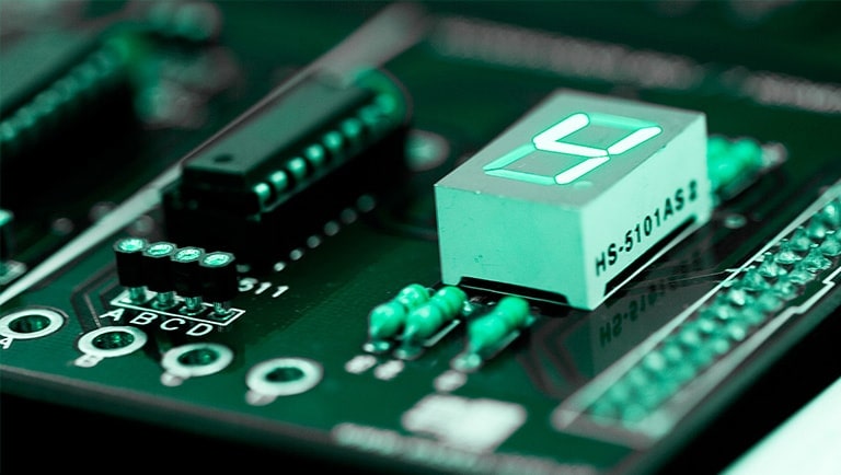 A complex circuit features a white rectangular component plugged in, boldly displaying the number four.