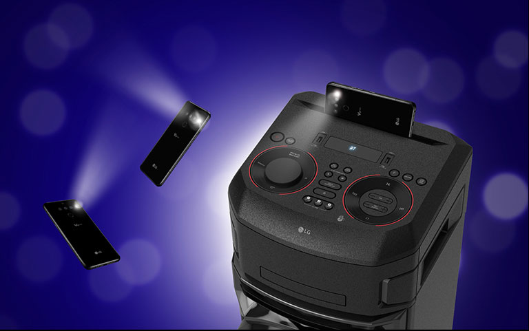 Vue rapprochée du dessus de l’enceinte LG XBOOM. Deux smartphones avec le flash allumé flottent autour de l’enceinte
