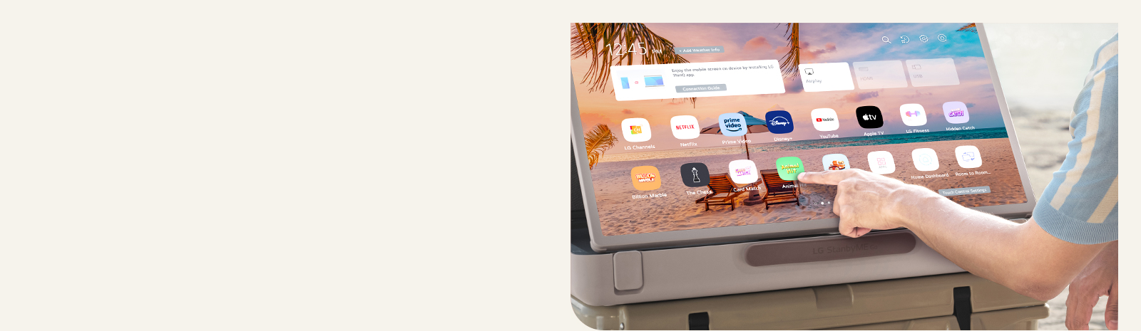 Zoom du LG StanbyME Go. Le produit est placé sur une table et l’écran pivoté à l’horizontale. Une main touche une icône.