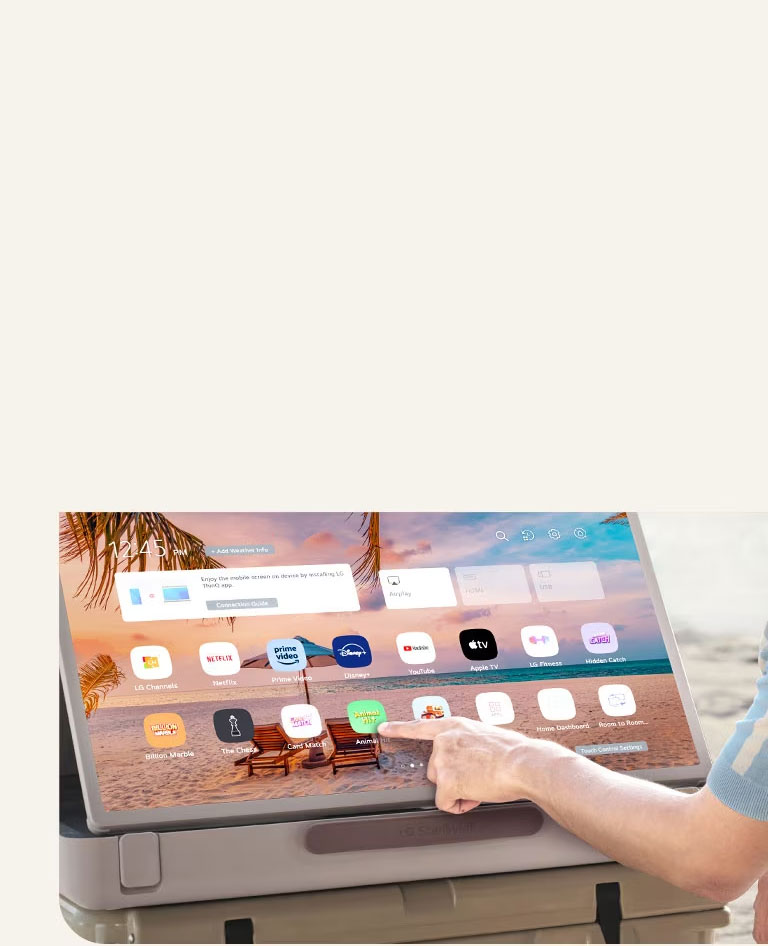 Zoom du LG StanbyME Go. Le produit est placé sur une table et l’écran pivoté à l’horizontale. Une main touche une icône.