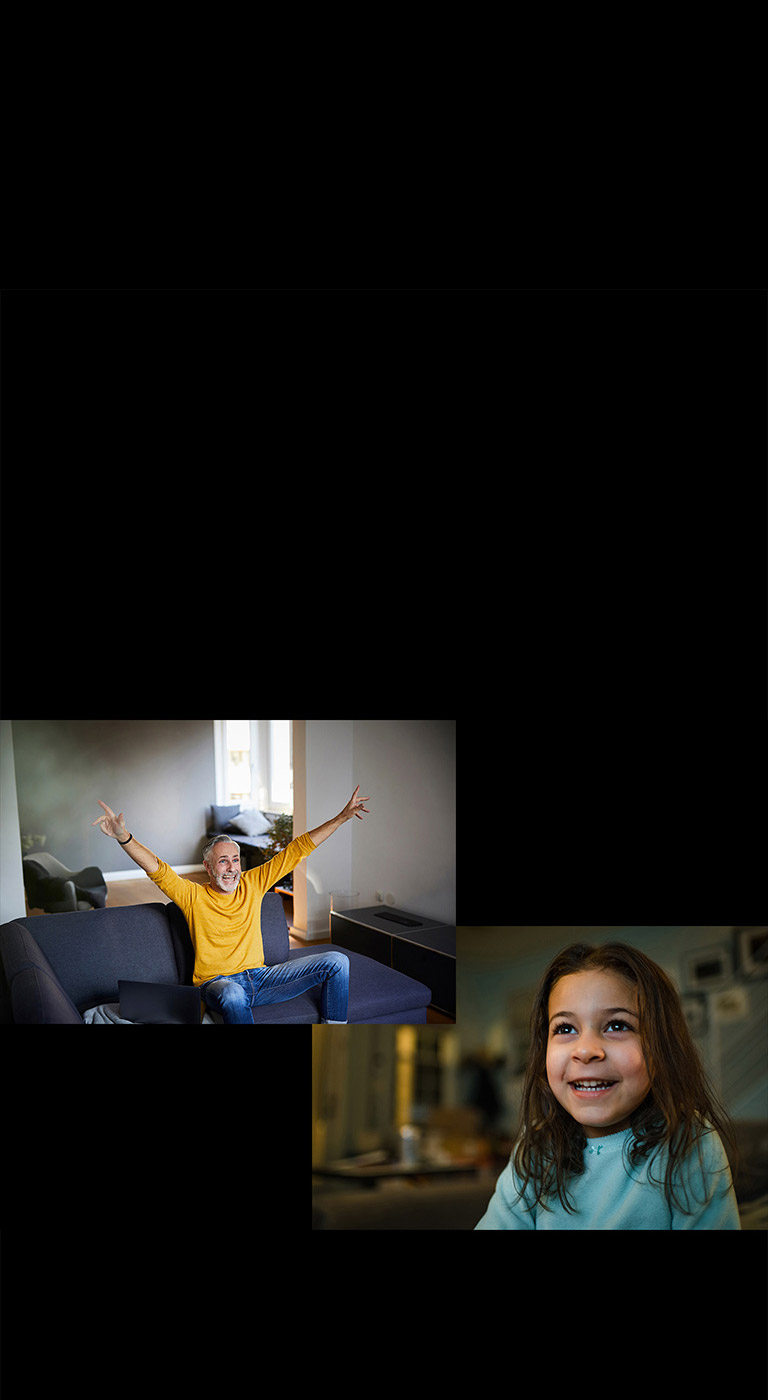 Un grand-père est assis sur un canapé dans le salon et regarde avec plaisir l’image diffusée dans le coin supérieur gauche. Une fille regarde quelque chose avec joie.