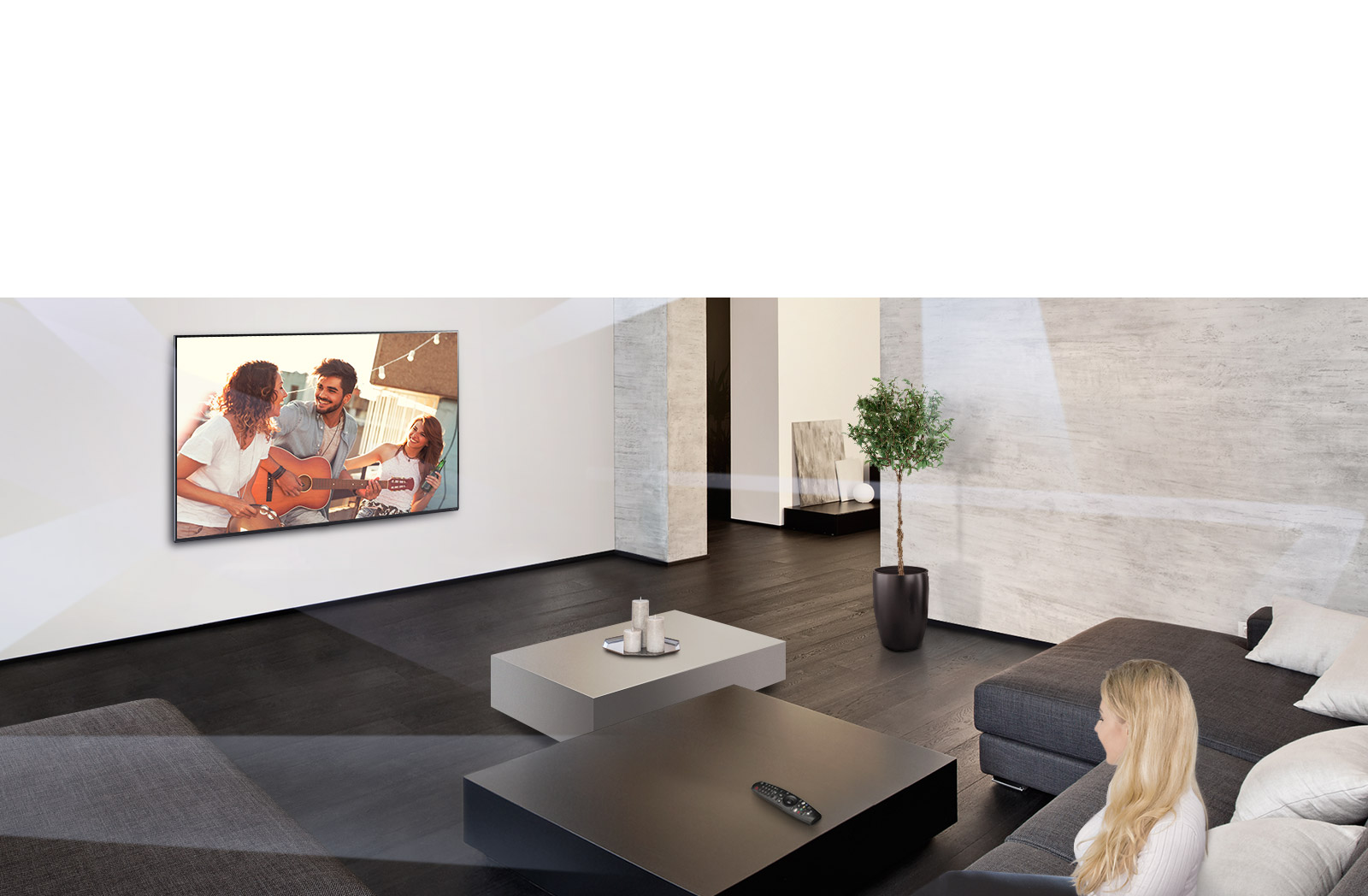 Une femme dans un grand salon à la décoration minimaliste en train de regarder des gens jouer sur un téléviseur