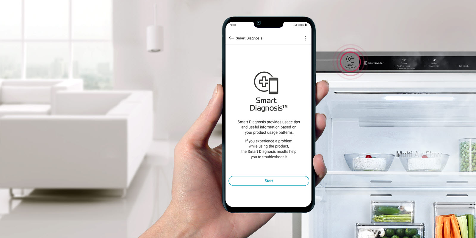 Une main tient un téléphone avec un réfrigérateur en arrière-plan. L’écran du téléphone affiche l’application Smart Diagnosis pour les alertes de maintenance.