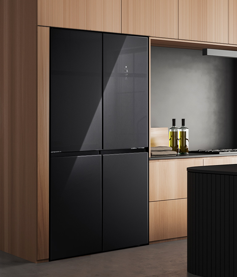 Intérieur de cuisine moderne avec réfrigérateur intégré, armoires en bois et îlot de cuisine avec tabourets.