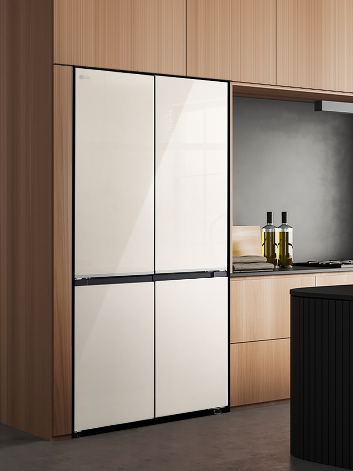 Intérieur de cuisine moderne avec réfrigérateur intégré, armoires en bois et îlot de cuisine avec tabourets.