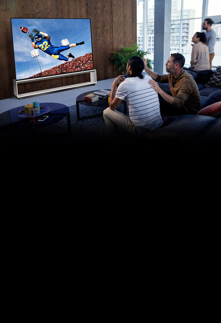 People watching a Tottenham game on TV in the living room