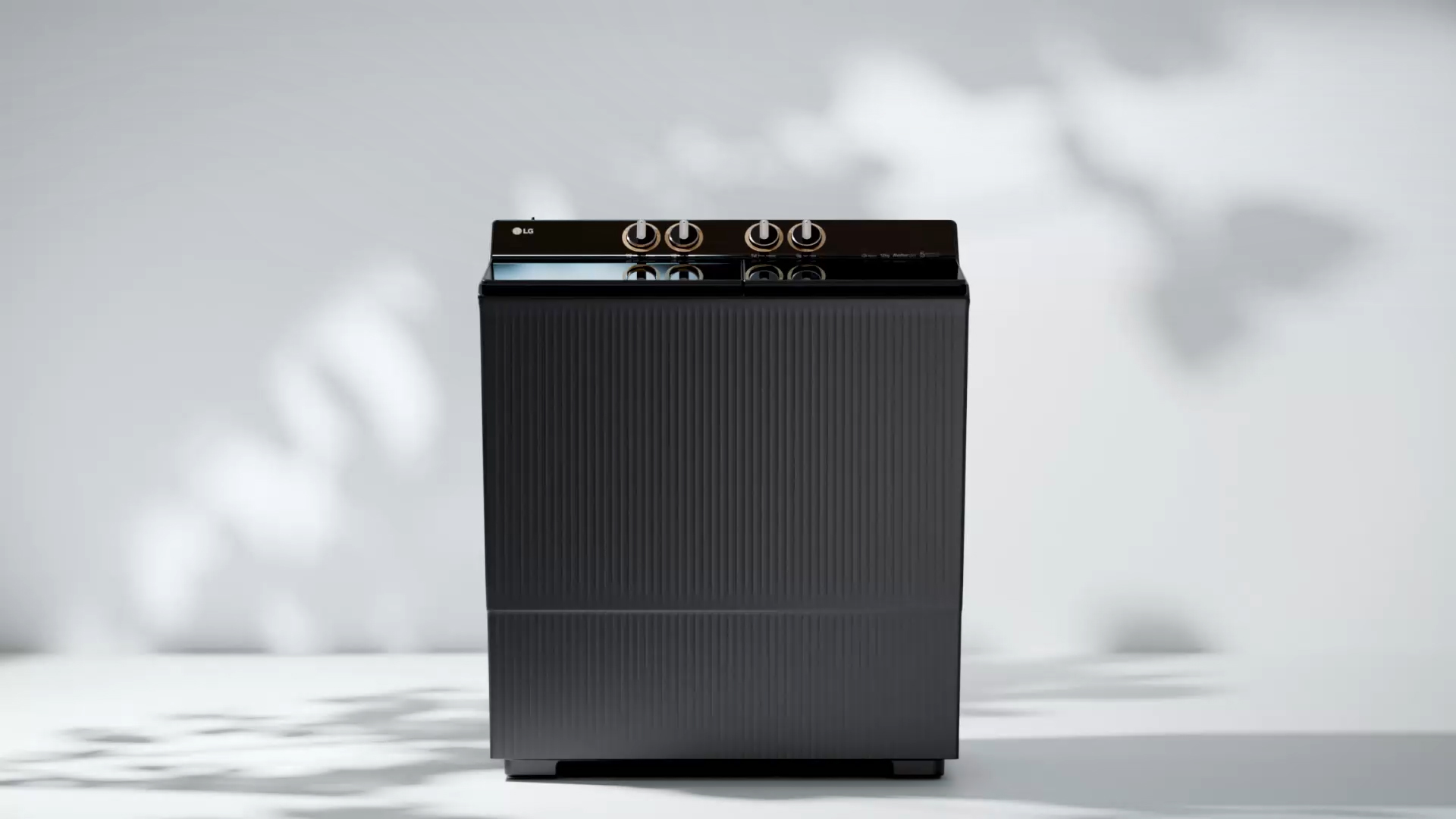 Vue avant d’une machine à laver moderne noire à chargement par le haut avec des molettes de commande sur le dessus, affichées sur un fond blanc épuré.