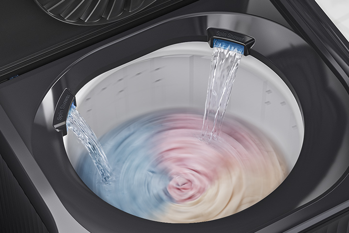 Une cuve de machine à laver à chargement par le haut avec deux jets d’eau coulant sur les vêtements, illustrant une douche à double rotation pour un rinçage uniforme.