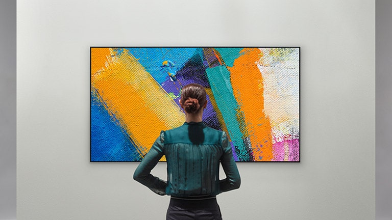 " Mujer disfrutando de una obra de arte abstracta en una galería de diseño de TV"