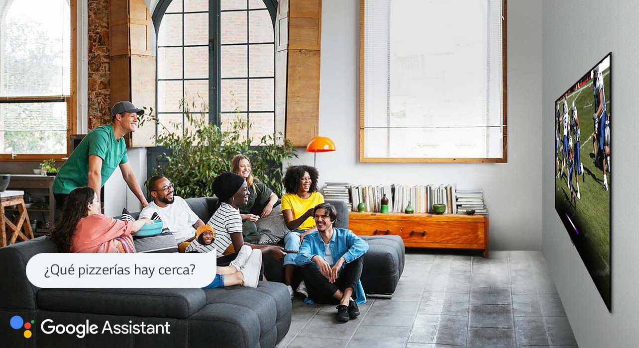 Mujer mirando fútbol en la TV con amigos y preguntándole al Asistente de Google qué pizzerías hay cerca