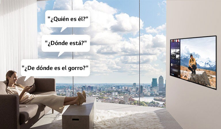Una mujer mirando y preguntando a la TV: "¿Quién es él?", "¿Dónde está?" y "¿De dónde es el gorro?" 
