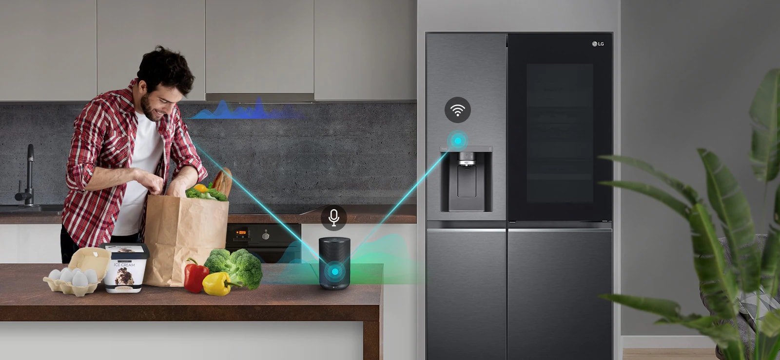 Un hombre está de pie en una cocina descargando productos de una bolsa de la compra y habla, mostrado por barras de volumen que suben y bajan cerca de él, al altavoz de la IA en el mostrador diciéndole que "encienda la congelación exprés". Aparece una línea que va desde el hombre hasta el altavoz de la IA que tiene un icono de micrófono encima. Luego aparecen barras de volumen cerca del altavoz de la IA y aparece una línea que va desde el altavoz de la IA hasta la nevera que tiene un icono de Wifi encima.