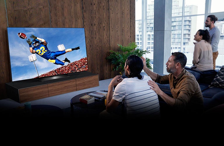 Personas viendo el juego de Tottenham en la televisión en la sala de estar