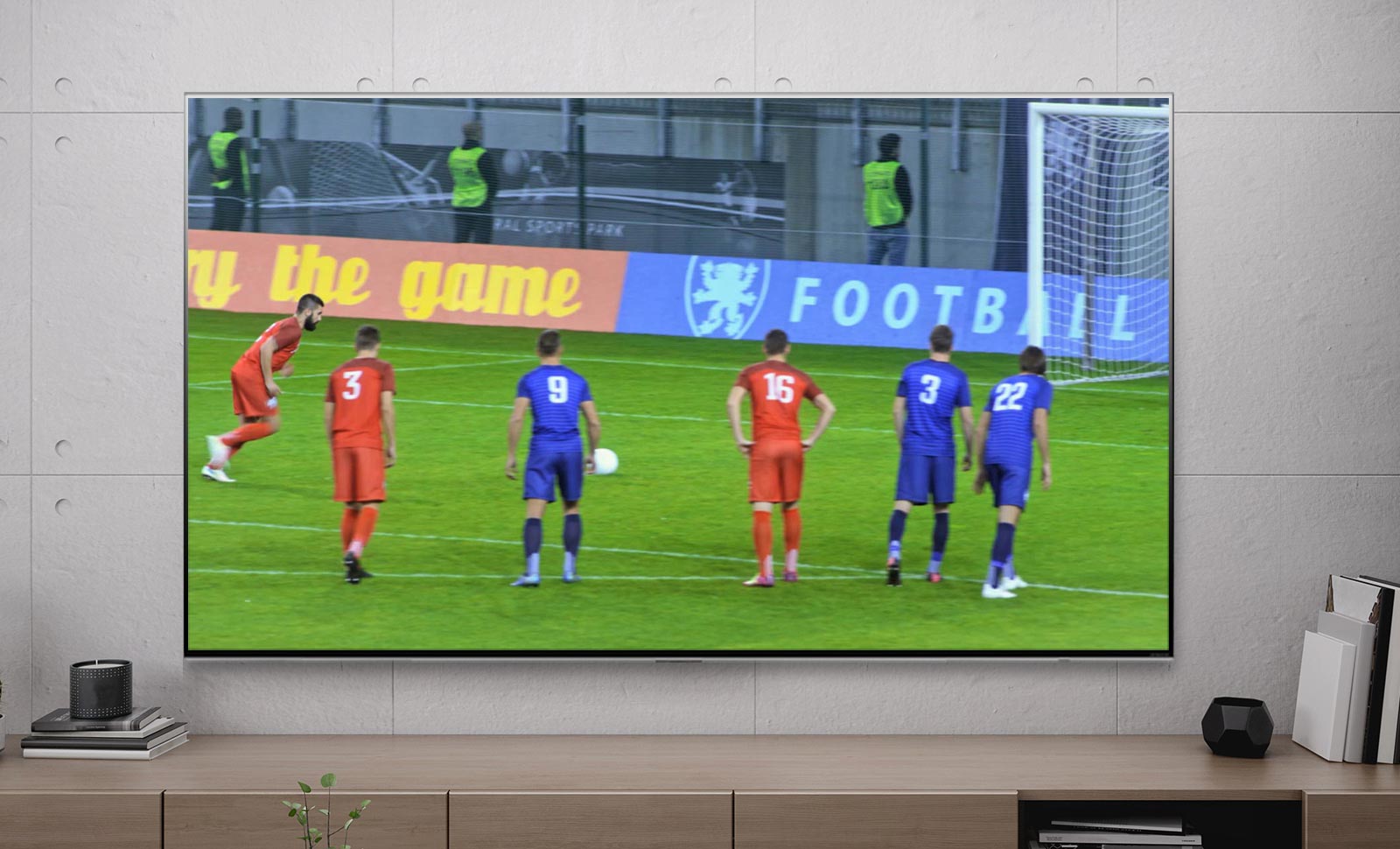 Una pantalla de televisión que muestra a un jugador de fútbol marcando un penalti (reproduce el vídeo).