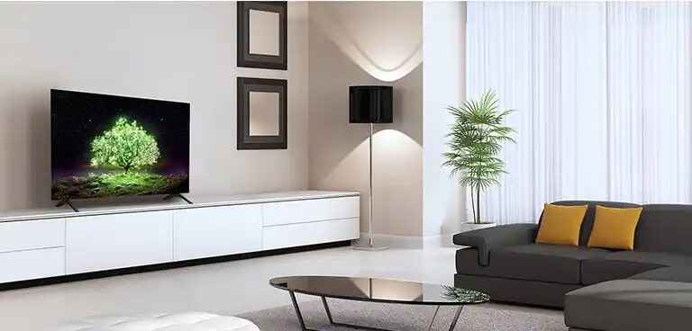 Un televisor OLED A1 colocado en una sala de estar sensual. En la televisión, puede ver una imagen de un árbol verde que brilla intensamente.