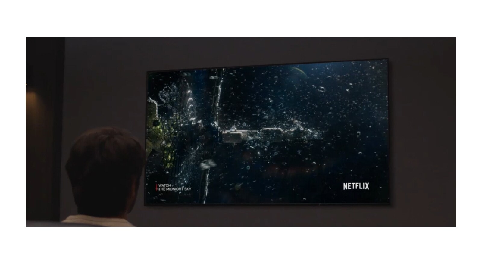 Un hombre que ve el contenido de Midnight Sky de Netflix en la sala de cine. Y el lema Sé el héroe es visible